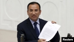 FILE - Turkish Deputy Prime Minister Bekir Bozdag, justice minister at the time, addresses Turkish lawmakers in Ankara, Turkey, March 19, 2014. Bozdag said Paris offering to mediate between Ankara and the YPG Syrian Kurdish militia amounted to supporting terrorism.