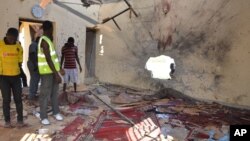 People inspect a damaged mosque following an explosion in Maiduguri, Nigeria, Oct. 23, 2015. Boko Haram is suspected to be behind bombing.