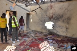 FILE - People inspect a damaged mosque following an explosion in Maiduguri, Nigeria, Oct. 23, 2015. Boko Haram is suspected to be behind bombing.