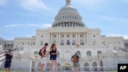 Туристи біля будівлі Капітолія США. В американській столиці гаряче не лише на вулиці, але і на дебатах по Україні в середині головного законодавчого органу США.