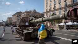 Un hombre con una bandera ucraniana visita una avenida donde se exhiben vehículos militares rusos destruidos antes del Día de la Independencia en Kiev, Ucrania, el lunes 21 de agosto de 2023. [Foto: Archivo/AP]