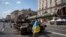 Un hombre que porta una bandera ucraniana visita una avenida donde se exhiben vehículos militares rusos destruidos antes del Día de la Independencia en Kiev, Ucrania, el lunes 21 de agosto de 2023. [Foto: Archivo/AP]