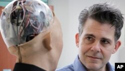 FILE - In this Sept. 28, 2017, photo, David Hanson, the founder of Hanson Robotics, talks with his company's flagship robot Sophia, a lifelike robot powered by artificial intelligence in Hong Kong.