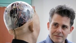 FILE - In this Sept. 28, 2017, photo, David Hanson, the founder of Hanson Robotics, talks with his company's flagship robot Sophia, a lifelike robot powered by artificial intelligence in Hong Kong.
