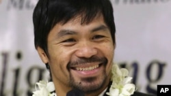 In this April 14, 2016 file photo - Filipino boxer and Congressman Manny Pacquiao smiles as he answers questions from reporters upon his arrival at the Ninoy Aquino International Airport in suburban Pasay city, south of Manila, Philippines, after beating American Timothy Bradley during their WBO welterweight title boxing match in Las Vegas.