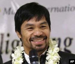 In this April 14, 2016 file photo - Filipino boxer and Congressman Manny Pacquiao smiles as he answers questions from reporters upon his arrival at the Ninoy Aquino International Airport in suburban Pasay city, south of Manila, Philippines, after beating