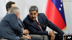 El candidato a la reelección presidencial, Nicolás Maduro, conversa con el también postulado Luis Eduardo Martinez, mientras Antonio Ecarri escucha entre ambos, en el CNE, el 20 de junio de 2024.