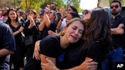 FILE - Abeer, center, sister of Reuters videographer Issam Abdallah who was killed by Israeli shelling, weeps during his funeral procession in his hometown of Khiam, southern Lebanon, Oct. 14, 2023.