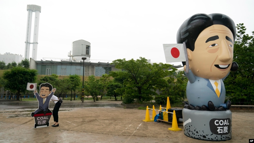 Tư liệu: Một nhà hoạt động dựng bảng chỉ trích Thủ tướng Shinzo Abe trước một nhà máy nhiệt điện than tại hội nghị thượng đỉnh G20 27/9/2019. Giới hoạt động đòi Tokyo ngưng tài trợ cho các nhà máy nhiệt điện than ở nước ngoài. (AP Photo/Jae C. Hong)