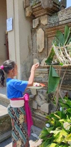 Warga Bali berdoa dengan sesaji di depan rumah. (Foto:VOA/ Nurhadi)