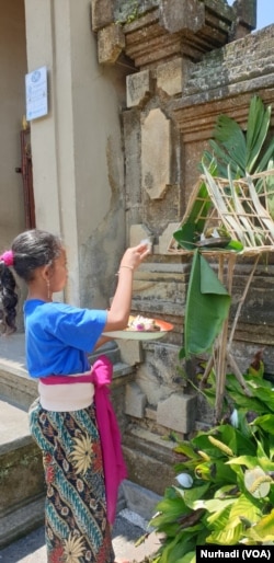 Warga Bali berdoa dengan sesaji di depan rumah. (Foto:VOA/ Nurhadi)