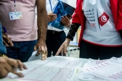 Election officials start counting marked ballots after polling stations closed during a parliamentary election in Tunis, Tunisia, Oct. 6, 2019.