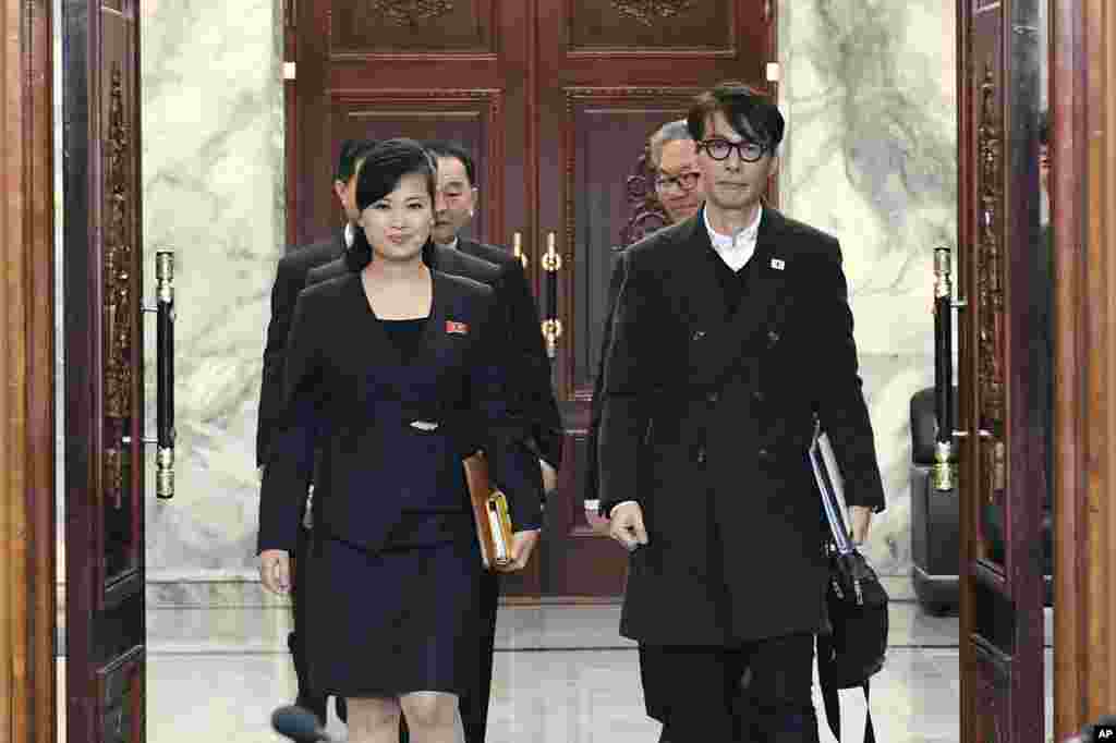 朝鲜一个艺术团团长玄松月(左)在板门店同韩国文化官员走入会场，准备讨论韩国艺术团访问平壤事宜(2018年3月20日)。 由玄松月率领的三池渊管弦乐团等114人艺术团2月8日在韩国演出。