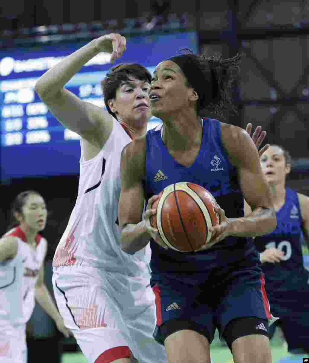 France forward Marielle Amant, right, looks for the basket defended by Japan forward Ramu Tokashiki during the first half of a women's basketball game at the Youth Center at the 2016 Summer Olympics in Rio de Janeiro, Brazil, Aug. 13, 2016. 