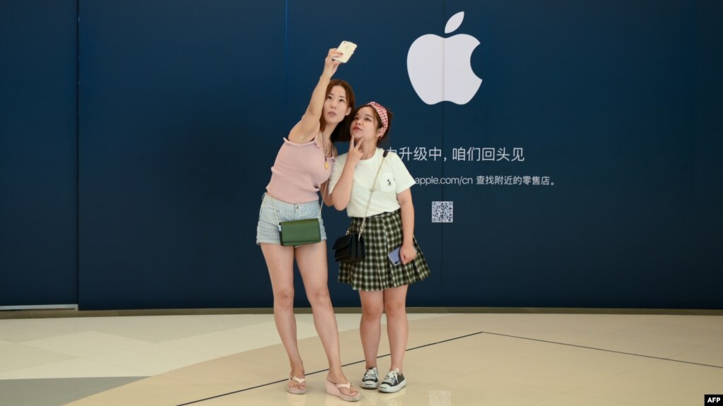 Khách hàng chụp ảnh tự sướng bên ngoài một cửa hàng Apple ở Bắc Kinh hôm 16/8.