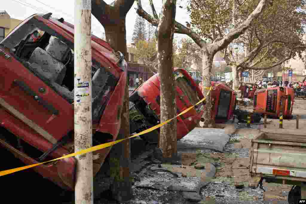 Damaged vehicles lie by a street after an oil pipeline exploded, killing at least 35 people, ripping roads apart, turning cars over and sending thick black smoke billowing over the city of Qingdao, east China&#39;s Shandong province. 