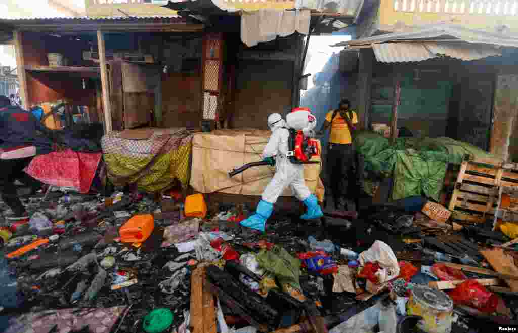 A member of local hygiene services wearing a protective suit and a face mask, disinfects the street and market to stop the spread of coronavirus disease (COVID-19) in Dakar, Senegal, March 22, 2020.