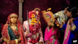 Vijay, 20, sits with his wife Preeti, 15, during mass marriage ceremony, Karachi, Nov. 12, 2011.