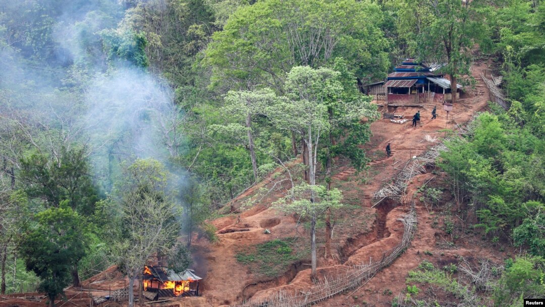 Pasukan etnis minoritas Karen terlihat setelah membakar sebuah bangunan di dalam pos militer Myanmar dekat perbatasan Thailand, yang terlihat dari sisi Thailand di Thanlwin, juga dikenal sebagai Salween, tepi sungai di Provinsi Mae Hong Son. (Foto: Reuters)