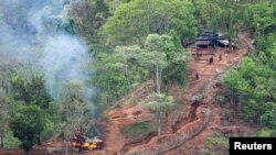 Pasukan etnis minoritas Karen terlihat setelah membakar sebuah bangunan di dalam pos militer Myanmar dekat perbatasan Thailand, yang terlihat dari sisi Thailand di Thanlwin, juga dikenal sebagai Salween, tepi sungai di Provinsi Mae Hong Son. (Foto: Reuters)