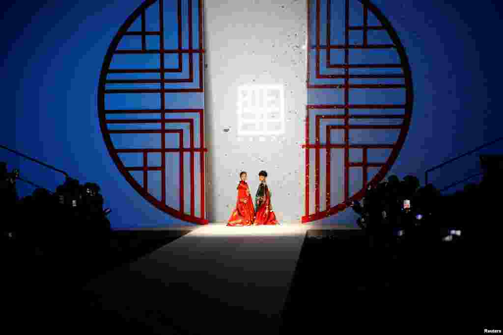 Child models present creations from the MIBAI Spring/Summer 2021 collection show by Qingmei Lou, during China Fashion Week in Beijing.