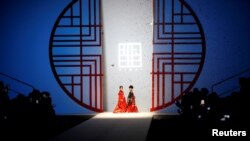 Child models present creations from the MIBAI Spring/Summer 2021 collection show by Qingmei Lou, during China Fashion Week in Beijing.
