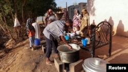 Displaced Sudanese families wait to receive food from a charity kitchen, as a year of war between Sudan's army and the paramilitary Rapid Support Forces (RSF) has driven more than 8.5 million people from their homes, in the city of Omdurman, Sudan, April 6, 2024. 