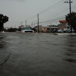 A car passes through a flooded street as storm Imelda hits Houston, Texas, Sept. 19, 2019, in this screen grab obtained from social media video.