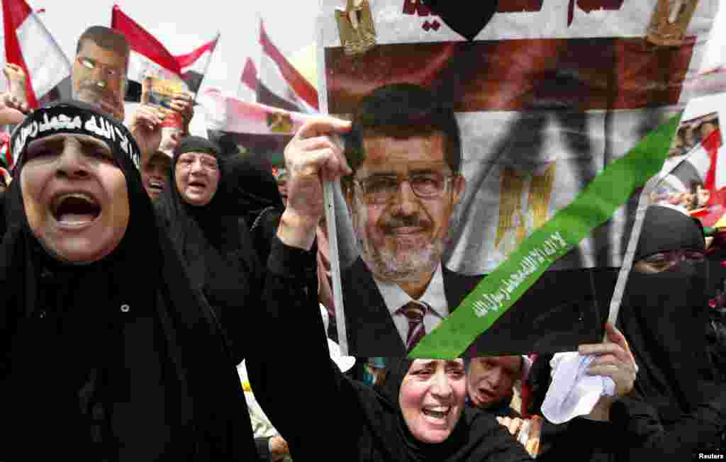 A supporter of deposed Egyptian President Mohamed Morsi holds up a sign with an image of Morsi as they protest at the&nbsp;Rabaa el-Adawiya square&nbsp;where they are camping in Cairo, July 19, 2013.&nbsp;