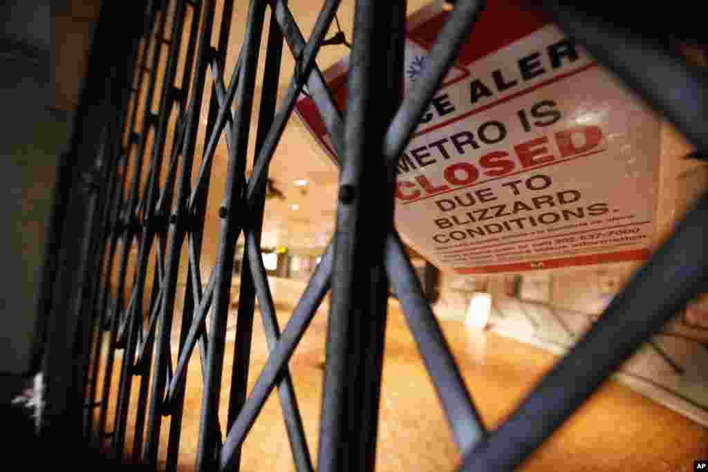 A sign at the entrance to the Smithsonian Metro stop reads that the system is closed due to the blizzard, Saturday, Jan. 23, 2016 in Washington. (AP Photo/Alex Brandon)