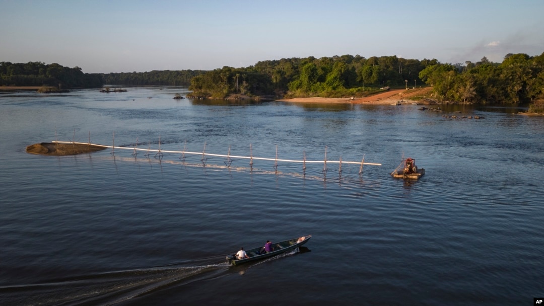 Warga melintasi sungai Essequibo di Guyana, pada 10 april 2023. Wilayah Essequibo kini menjadi perebutan antara Venezuela dan Guyana. (Foto: AP/Matias Delacroix)