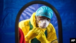 FILE -A healthcare worker dons protective gear before entering an Ebola treatment center in the west of Freetown, Sierra Leone,Oct. 16, 2014..