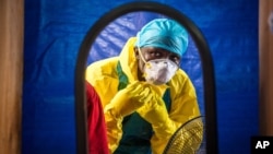 FILE -A healthcare worker dons protective gear before entering an Ebola treatment center in the west of Freetown, Sierra Leone,Oct. 16, 2014..