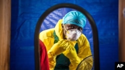 FILE -A healthcare worker dons protective gear before entering an Ebola treatment center in the west of Freetown, Sierra Leone,Oct. 16, 2014..