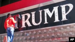 FILE - A worker removes letters from a Trump logo in Atlantic City, N.J.China has granted preliminary approval for 38 new Trump trademarks, fueling concerns about conflicts of interest and preferential treatment of the U.S. president.