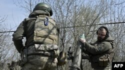 FILE - Belarusian volunteer soldiers from the Kastus Kalinouski Regiment prepare a 120 mm mortar at a front-line position near Bakhmut in the Donetsk region, on April 9, 2023, amid the Russian invasion of Ukraine.