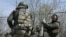 FILE - Belarusian volunteer soldiers from the Kastus Kalinouski Regiment prepare a 120 mm mortar at a front-line position near Bakhmut in the Donetsk region, on April 9, 2023, amid the Russian invasion of Ukraine.