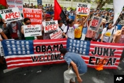 Protesters burn mock American flags during a rally outside of the US Embassy to protest alleged US military's involvement in the row between the Philippines and China on the disputed islands in the South China Sea, Thursday, in Manila, Philippines, Nov. 1