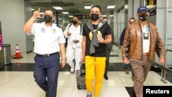 Cuban journalists Hector Valdez and Esteban Rodriguez, both reporters with the independent news website ADN Cuba, walk out of El Salvador International Airport upon their arrival in El Salvador, in San Luis Talpa, Jan. 5, 2022. 