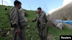 Kurdistan Workers Party (PKK) fighters talk to each other as they stand guard at the Qandil mountains near the Iraq-Turkish border in Sulaimaniya, 330 kilometers northeast of Baghdad, Iraq, March 24, 2013.