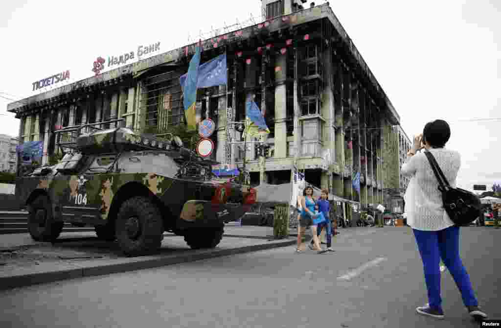A woman takes a picture of an armoured vehicle in Independence Square, Kyiv, May 23, 2014.