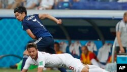 Pemain timnas Polandia, Bartosz Bereszynski (depan), bersaing berebut bola dengan pemain Jepang, Gaku Shibasaki, dalam laga penyisihan Grup H Piala Dunia 2018 antara Jepang dan Polandia di Volgograd Arena di Volgograd, Rusia, 28 Juni 2018. 