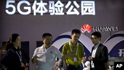 Visitors look at a display for 5G wireless technology from Chinese technology firm Huawei at the PT Expo in Beijing, China, Sept. 26, 2018.