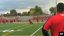 Dunbar High School Football Coach Craig Jefferies watches his team practice