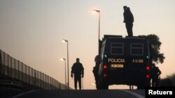 FILE - Spanish riot police patrol along the fence between Morocco and Spain's north African enclave Melilla, March 24, 2014.