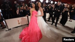 Stephanie Hsu and Michelle Yeoh pose on the champagne-colored red carpet during the Oscars arrivals at the 95th Academy Awards in Hollywood, Los Angeles, California, March 12, 2023. 