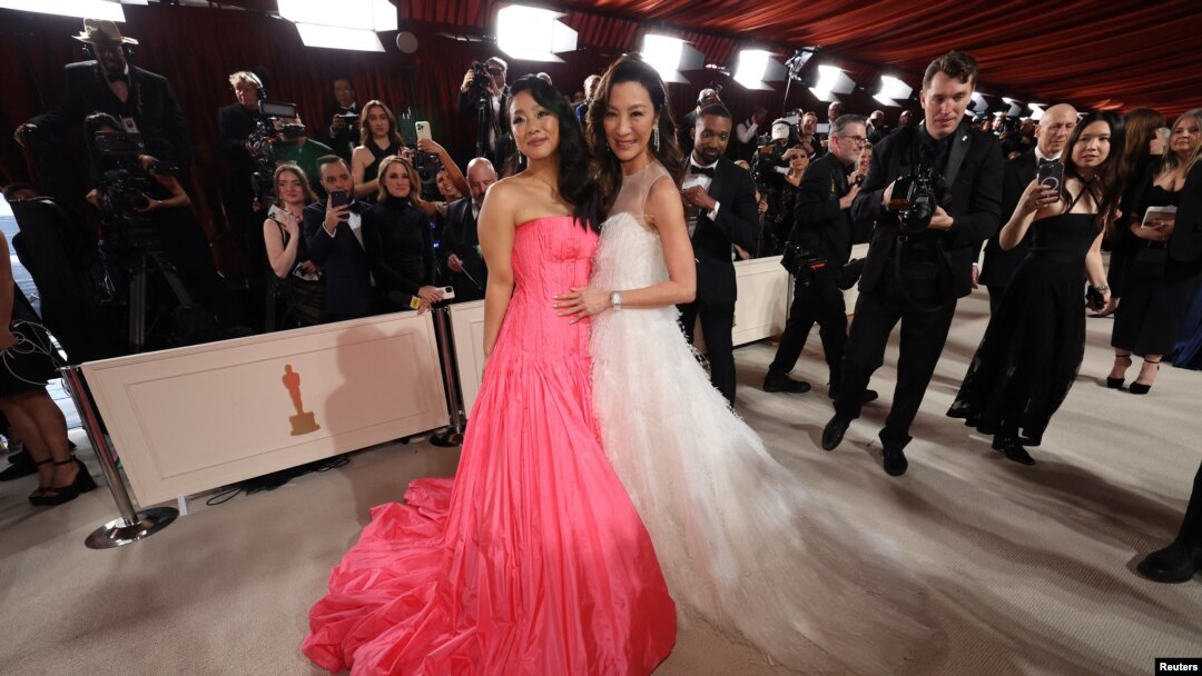 Aktris Stephanie Hsu dan Michelle Yeoh berpose untuk para fotografer saat tiba di ajang Oscars di Los Angeles, pada 12 Maret 2023. (Foto: Reuters/Mario Anzuoni)
