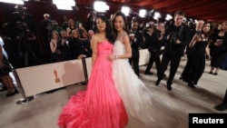 Aktris Stephanie Hsu dan Michelle Yeoh berpose untuk para fotografer saat tiba di ajang Oscars di Los Angeles, pada 12 Maret 2023. (Foto: Reuters/Mario Anzuoni)
