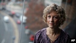 FILE - Karen Schneider, the vice president of communications at the National Women's Law Center, poses for a photo in National Women's Law Center offices in Washington, Dec. 5, 2017. 