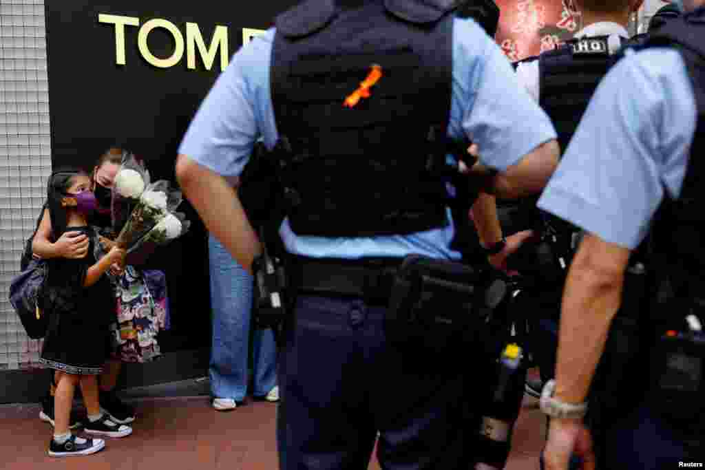 A mother and child holding flowers are stopped by police as they try to pay tribute to a man, who stabbed a policeman then stabbed himself and died on the anniversary of the city&#39;s return to Chinese rule, at Causeway Bay in Hong Kong, China.